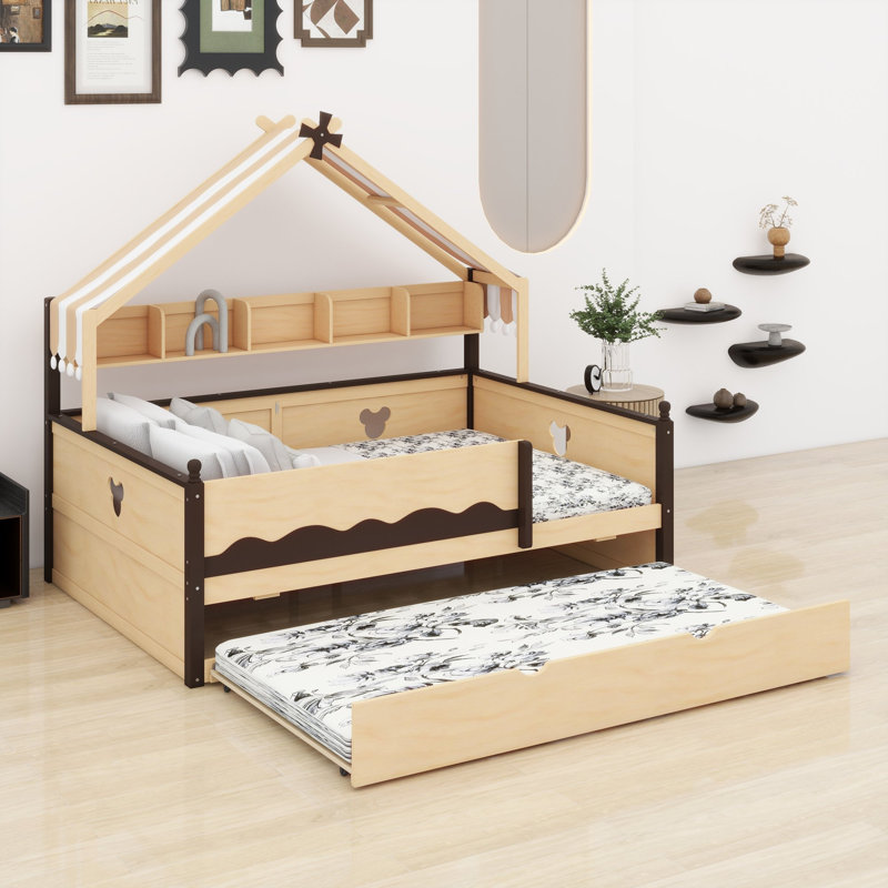 Le lit de jour avec lit gigogne et tablette est doté d'une structure à baldaquin en forme de maison pour les chambres d'enfants.