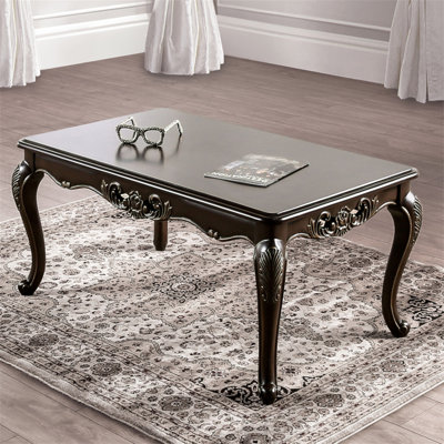 Table basse de style traditionnel avec pieds courbés et structure sculptée en bois massif