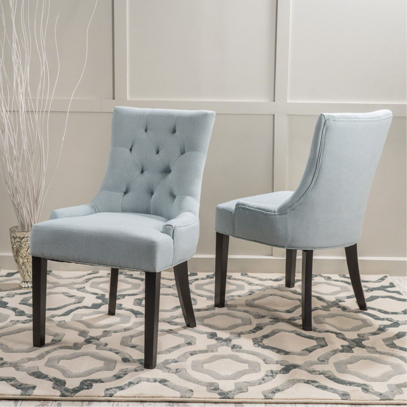 Chaise de salle à manger contemporaine capitonnée avec siège rembourré et pieds en bois, un ajout élégant et confortable à toute salle à manger.