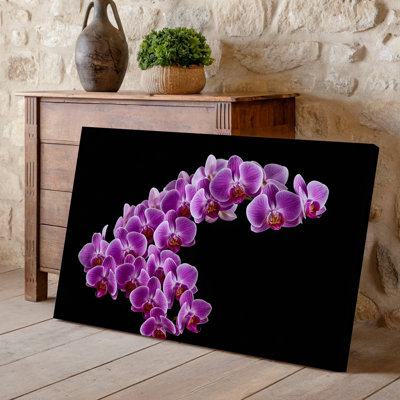 Toile Un arrangement délicat d'orchidées mauves éclatantes en cascade gracieuse contre un art mural sur fond noir