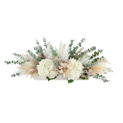 Arrangement d'hortensias, de pampas et d'eucalyptus dans un bol en bois