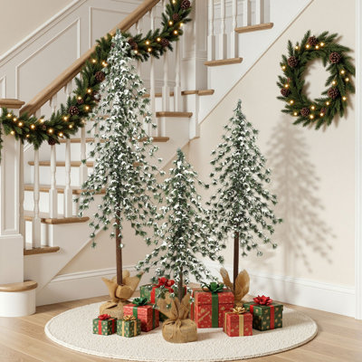 Ensemble d'arbres de Noël artificiels saupoudrés de neige avec bases recouvertes de toile de jute