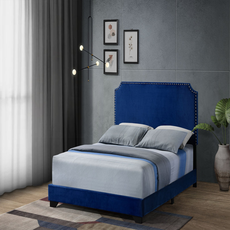 Grand lit en velours bleu avec garniture cloutée, pieds en bois et fabrication robuste pour un sommeil élégant et confortable