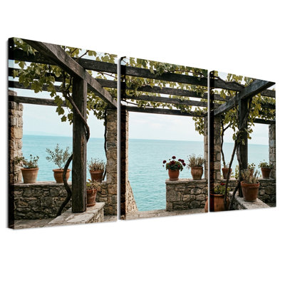 Pergola en bois surplombant une mer turquoise avec pierres - Ensemble de 3 toiles murales