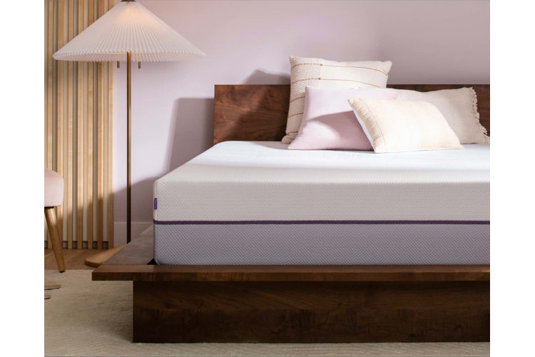 a bare memory foam mattress on a solid wood bed frame