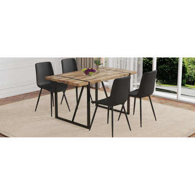 Ensemble de table et de chaises.Une table de salle à manger rectangulaire rétro minimaliste avec un plateau texturé et des pieds en métal noir. Assortie de 4 chaises en polyuréthane artificiel noir avec un design de coussin incurvé.