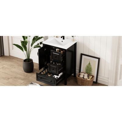 Meuble-lavabo noir autoportant de 61 cm (24 pouces) avec lavabo en céramique nécessitant peu d'entretien, rangement à fermeture amortie et poignées rétro. Armoire à fermeture centrale à un seul trou et plusieurs tiroirs.