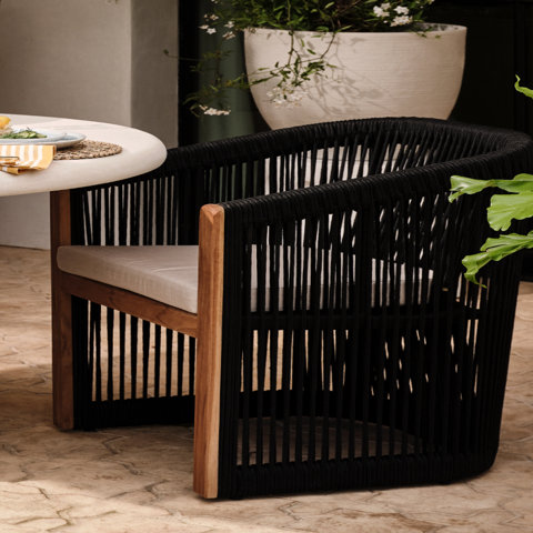 Wicker chair with white cushion.