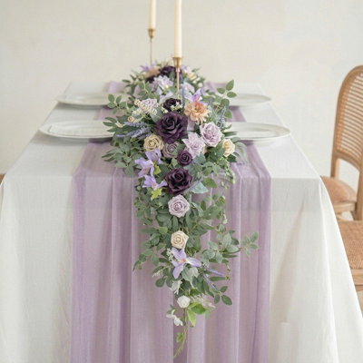 Guirlande de mariage avec guirlande florale avec chemin de table en chiffon, vigne de verdure et nappe diaphane