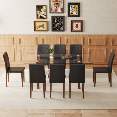 Ensemble de table et de chaises. Table de salle à manger élégante en verre trempé transparent - 71 po x 35,4 po avec chaises en polyuréthane et pieds en métal de couleur noyer. Mélange parfait de simplicité et de transparence.