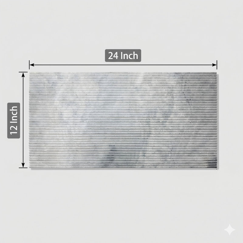 Véritables carreaux de marbre de Carrare dans une teinte grise, de taille 12 par 24 pouces, pour une utilisation sur les murs. La surface présente une finition texturée et un motif cannelé tridimensionnel en relief. Ceci est un produit en pierre naturelle authentique. Une seule boîte peut contenir quatre carreaux.