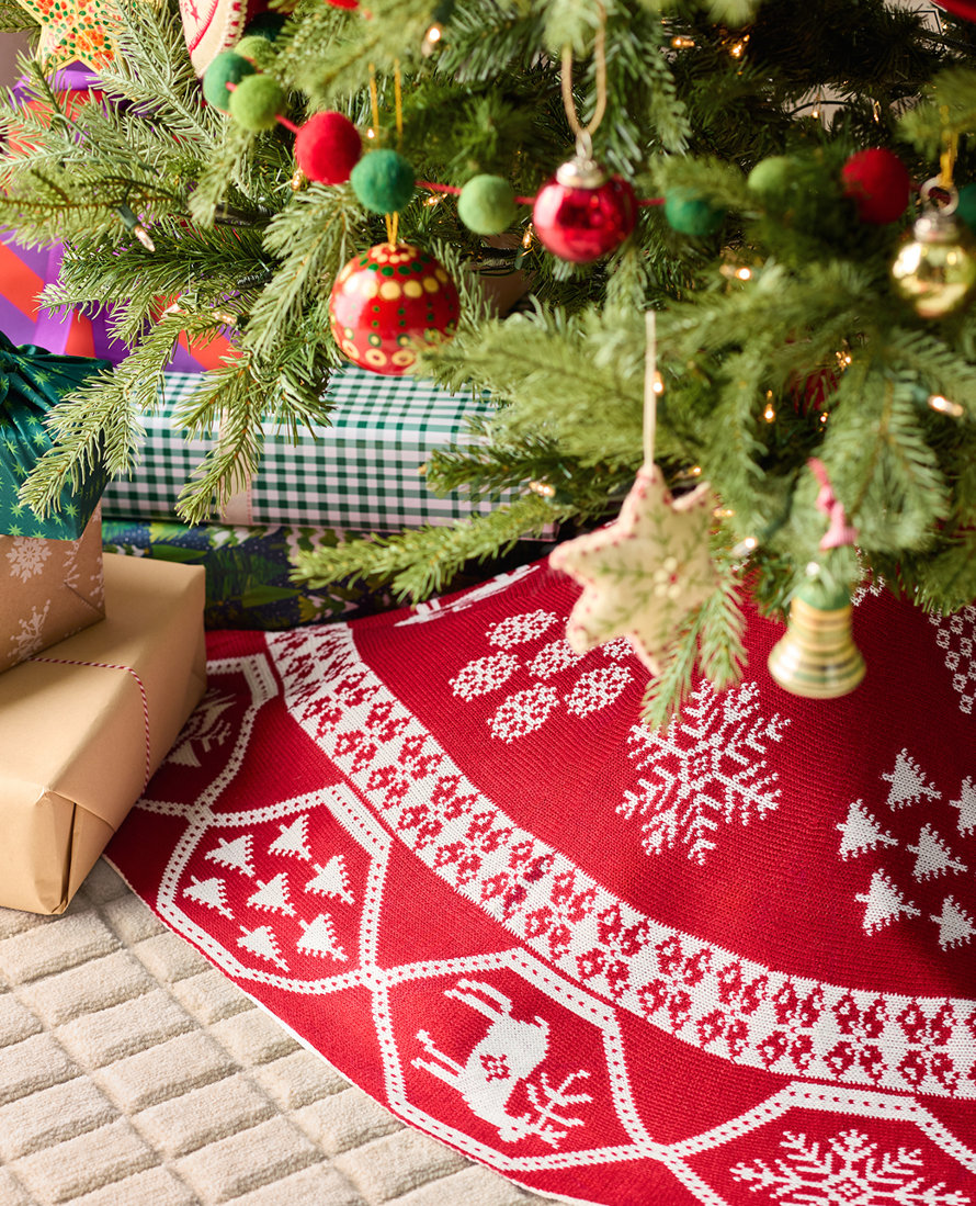 Christmas tree with gifts and a red and white tree skirt.