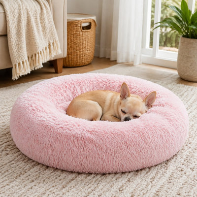 Coussin rond en forme de beigne rose de 20 x 20 x 8 pouces pour petits chiens, chats et chiots, avec une fourrure synthétique moelleuse, une conception lavable et un design apaisant anti-anxiété pour un sommeil confortable.