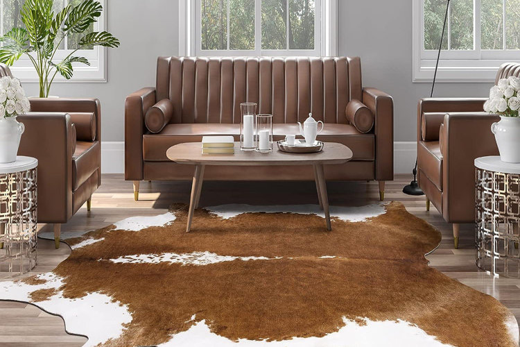 brown cowhide rug in modern living room with brown leather sofas and mid-century wood coffee table