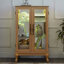 Élégante petite vitrine avec éclairage intégré, dossier et structure en miroir pour objets de collection.