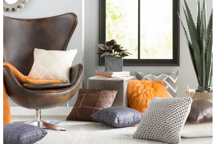 A variety of cushions with a leather accent chair