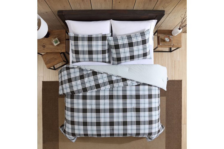 Bed with black-and-white plaid bedding and pillows.