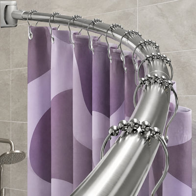 Cette barre de douche incurvée en acier inoxydable argenté est réglable de 35 à 76 pouces ; sa conception ronde en métal résistant à la rouille est destinée à créer un grand espace de douche dans les salles de bain et nécessite un perçage.