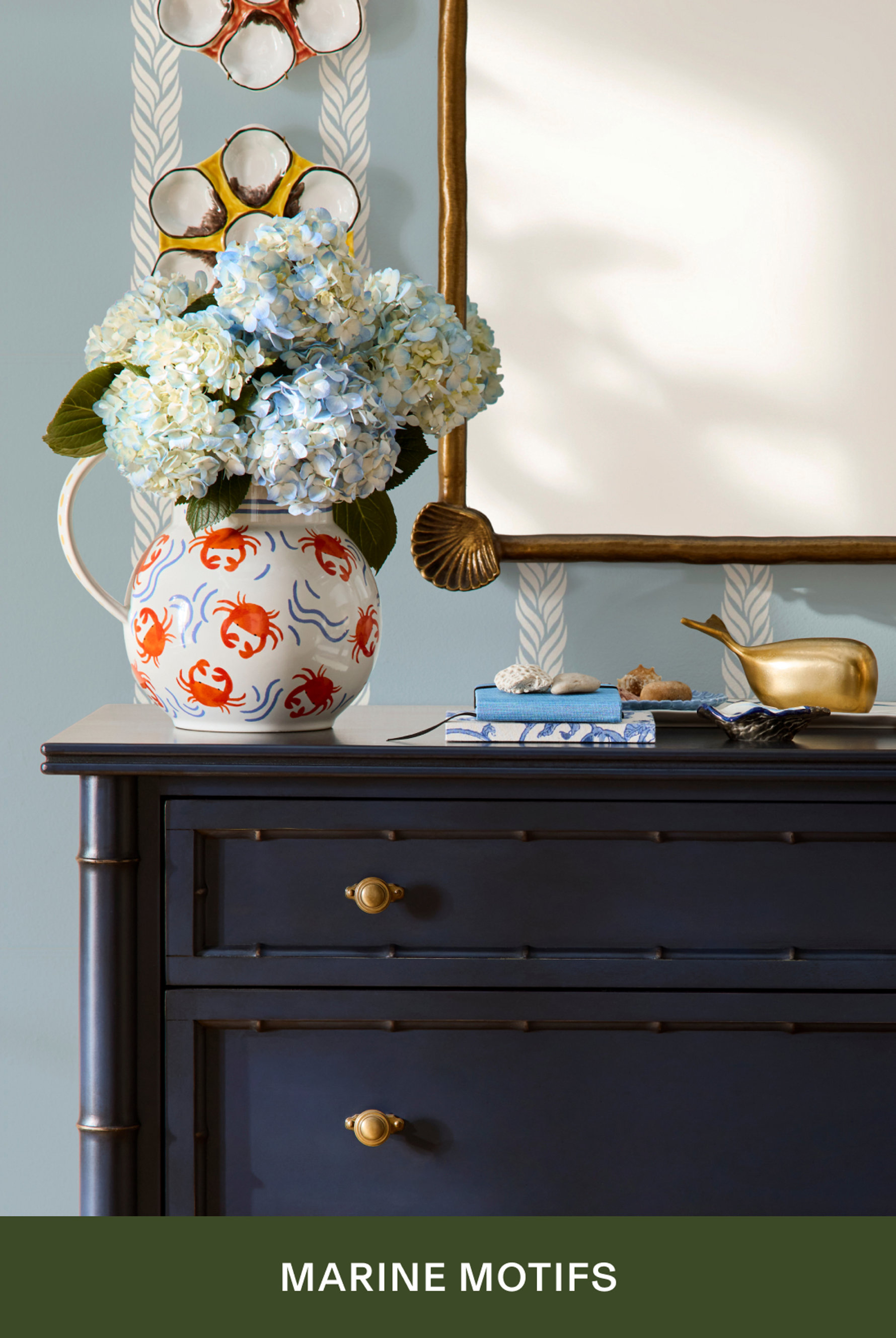 Marine Motifs - navy dresser with crab-patterned pitcher filled with hydrangeas and coastal decor
