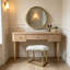 Tabouret de coiffeuse minimaliste moderne en fausse fourrure blanche avec structure en métal doré et miroir rond HD à base gris pâle