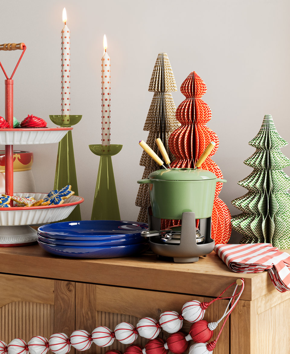 Christmas holiday themed dining table with fondue set, tiered serving stand, and paper trees.