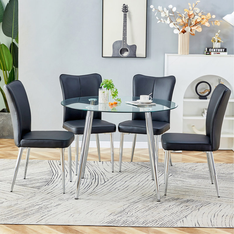 Ensemble de table et de chaises.Une table de salle à manger ronde en verre trempé transparent de 38,6 po de diamètre - Pieds en métal argenté. Comprend 4 chaises en polyuréthane noir avec un motif à rayures verticales sur le dossier.