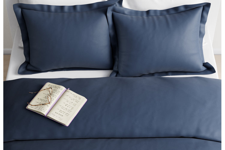 navy blue comforter on top of white sheets