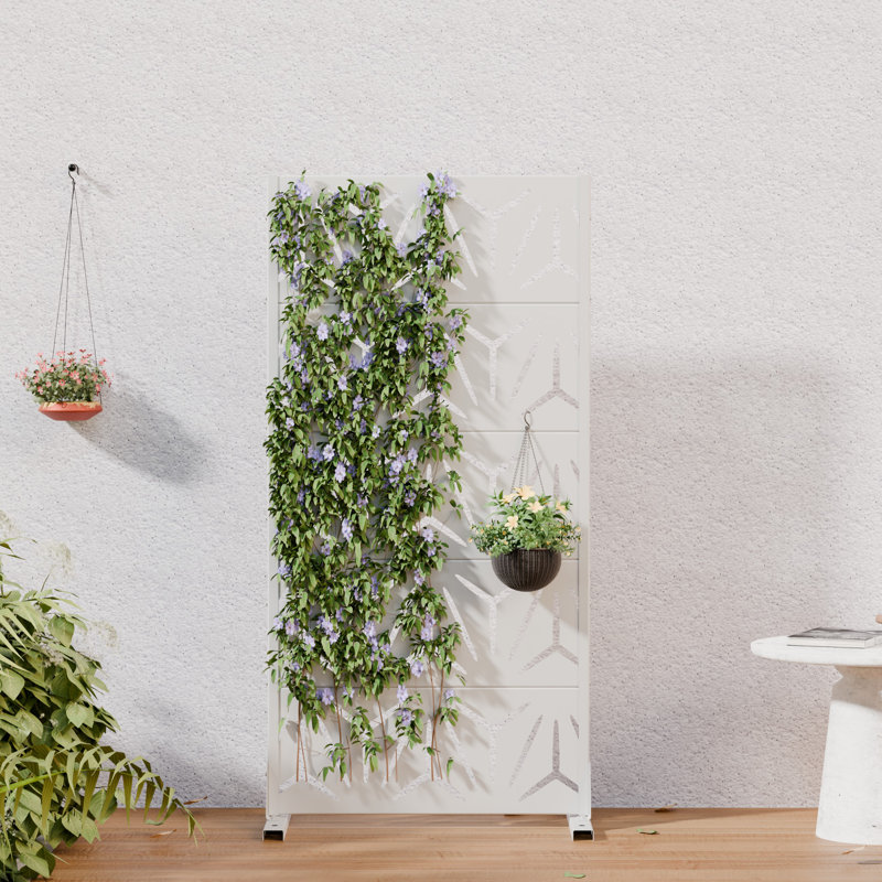 White metal privacy screen with a geometric lattice design, featuring climbing vines and hanging planters in a room setting.