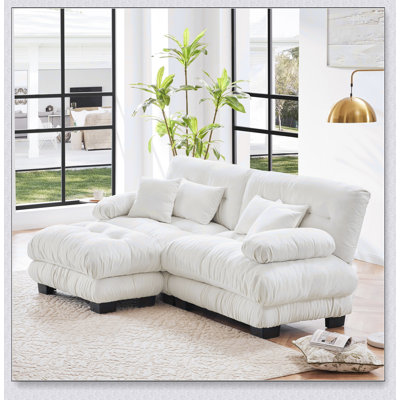 Luxueux canapé en chenille pour le salon avec plusieurs coussins et repose-pieds convertible, pour plus de confort et de style.