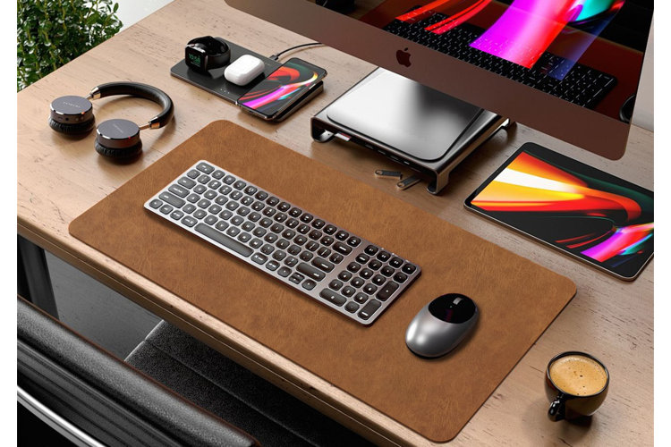 large desk with a brown leather-inspired desk pad beneath a keyboard
