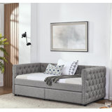 Twin sized upholstered daybed featuring two drawers, adorned with buttons and copper nails on its square arms