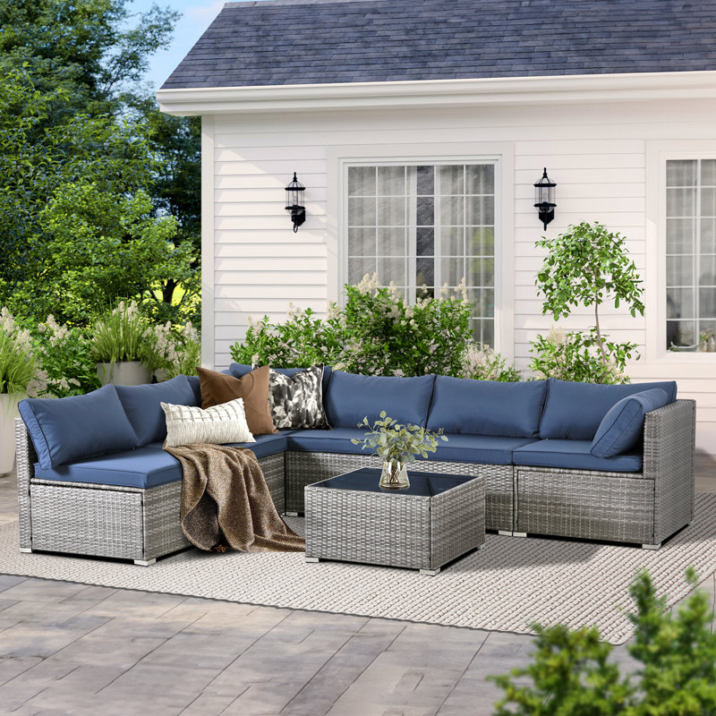 Ensemble de conversation modulaire de 7 pièces en résine tressée résistant aux intempéries pour patio, avec coussins et table basse.