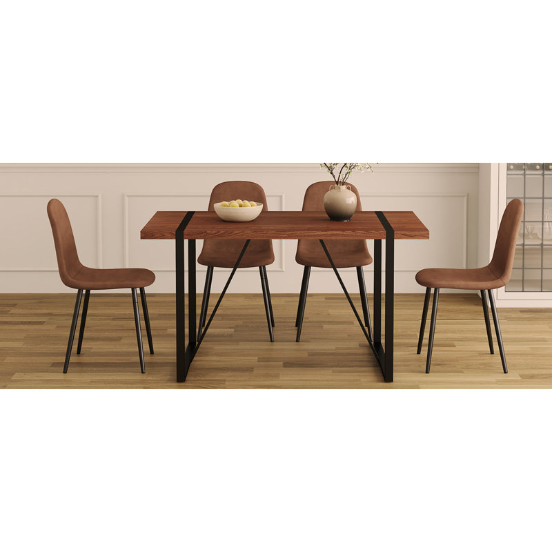 Ensemble de table et de chaises. Une table de salle à manger avec des pieds en métal noir, jumelée à 4 chaises douces et des pieds en métal noir