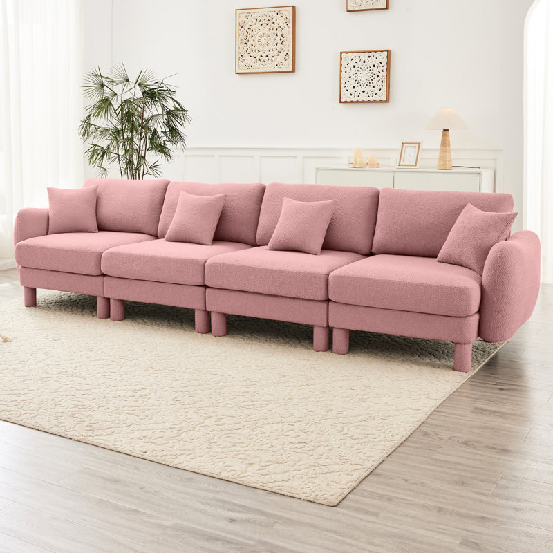 Tissu bouclé rose à 4 places avec sièges élégamment courbés et supportés par des ressorts pour un endroit confortable et moderne avec des pieds cylindriques en tissu