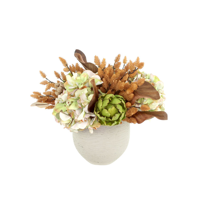 Centre de table d'automne avec hortensias, artichauts et pommes de pin