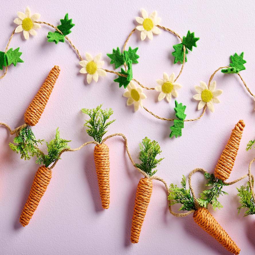 Carrot and Daisy garland displayed on a pink surface