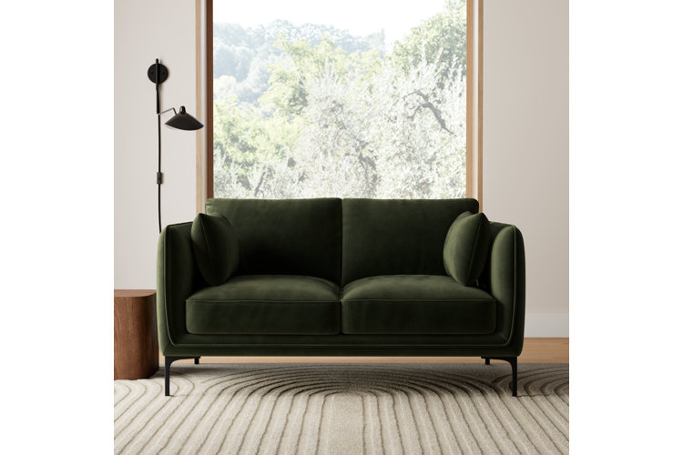 dark green velvet loveseat in a mid-century modern living room