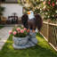 Statue de jardin debout sur une base en fausse pierre avec pot de fleurs rustique