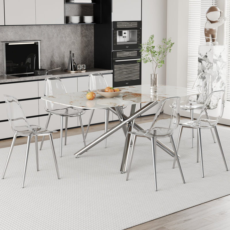 Ensemble de table de salle à manger moderne et luxueux en marbre blanc à motif en verre trempé avec chaises en plastique transparent, pieds argentés, pieds de table en métal argenté à une fourchette, idéal pour les salles à manger élégantes