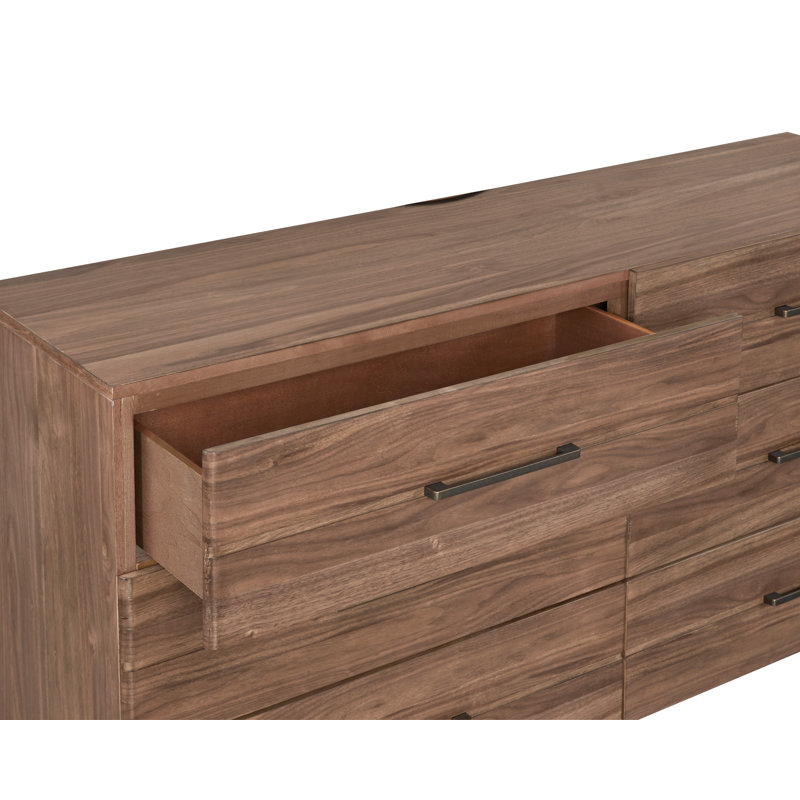 La commode et la commode avec une finition en bois clair et des poignées foncées minces allient simplicité moderne et rangement spacieux pour la chambre à coucher