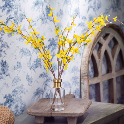 Arrangement d'illusion d'eau de source jaune Forsythia dans un grand vase de bouteille à rebord doré