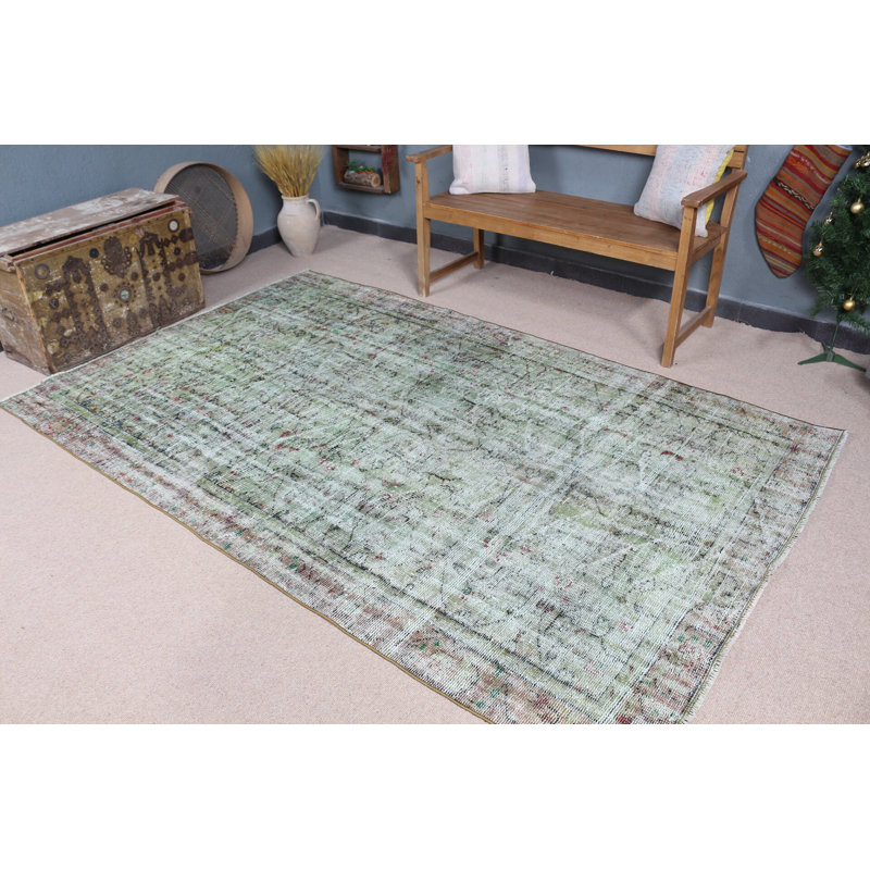 Tapis turc vintage vert avec un motif délavé unique pour une décoration intérieure élégante dans des tons pastel doux