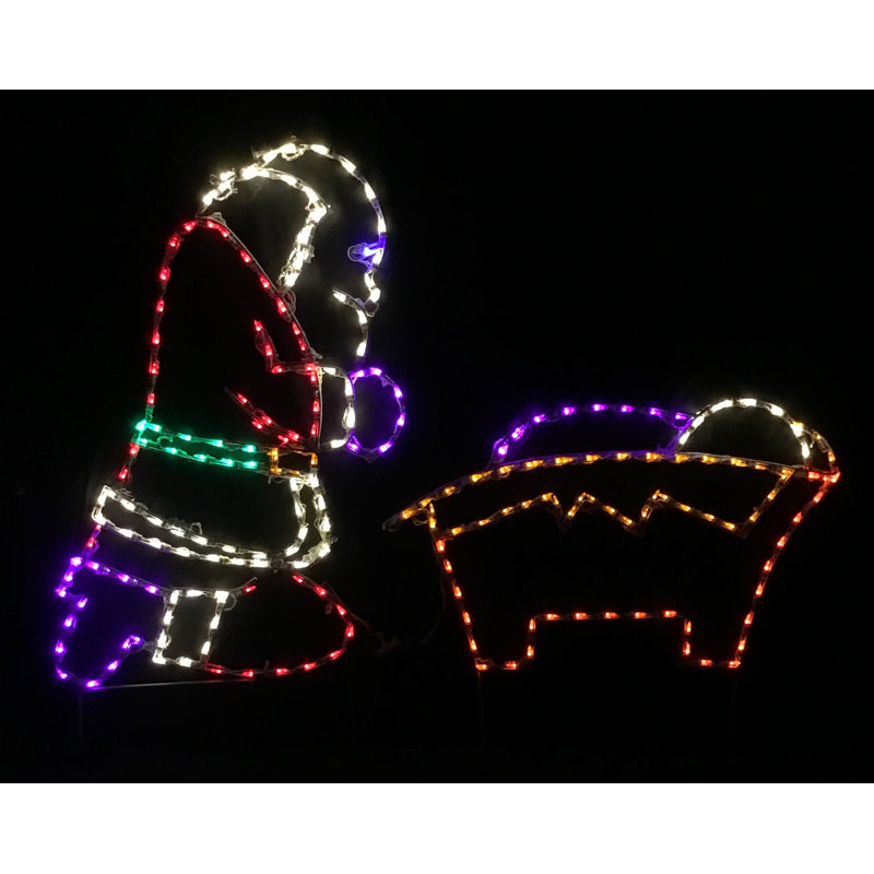 Père Noël agenouillé à la crèche de Noël