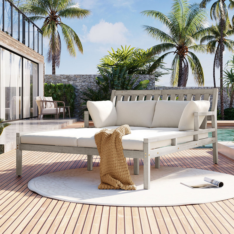 Lit de jour d'extérieur avec quatre coussins et accoudoirs courbés pour le jardin, la piscine ou la terrasse.