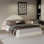 Lit arqué unique avec petite table, combinant design moderne et fonctionnalité pour une expérience de chambre à coucher élégante.