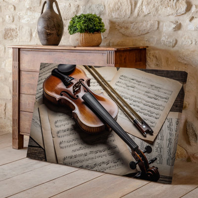 Toile, un violon en bois magnifiquement conçu repose élégamment sur une surface en bois patinée entourée de feuilles d'art rétro sur toile