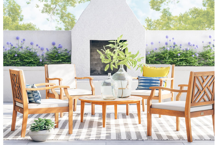 outdoor patio with mediterranean interior design inspo wooden seating with off-white cushions and blue and yellow cushions