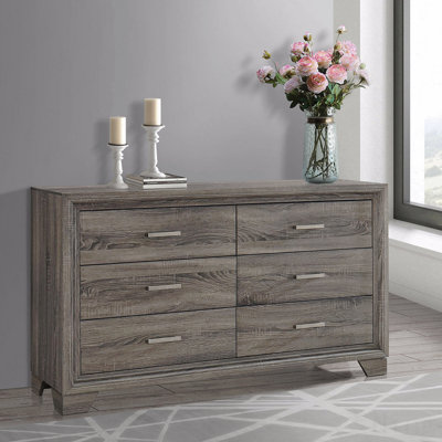 La commode et la commode avec une finition en bois rustique et des poignées subtiles allient charme rétro et rangement spacieux dans la chambre à coucher