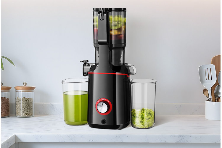 black masticating juicer on kitchen counter with juice and pulp containers