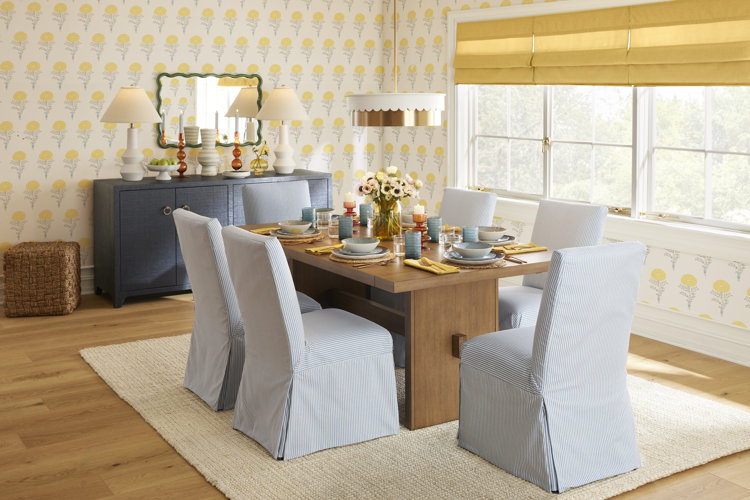 farmhouse dining room with butter yellow floral wallpaper and blue striped dining chairs